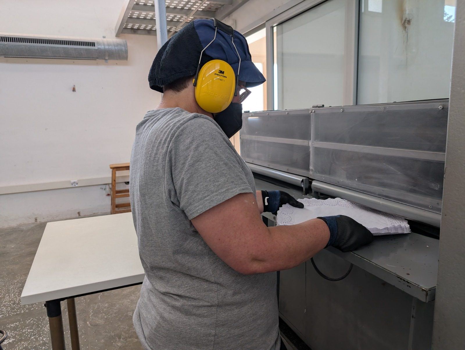 Persona treballant amb maquinària d'impremta i estampació