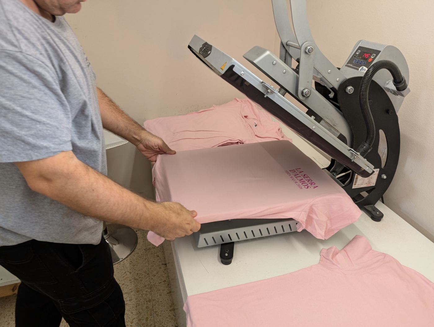 Persona estampant samarretes al taller ocupacional d'AJEM