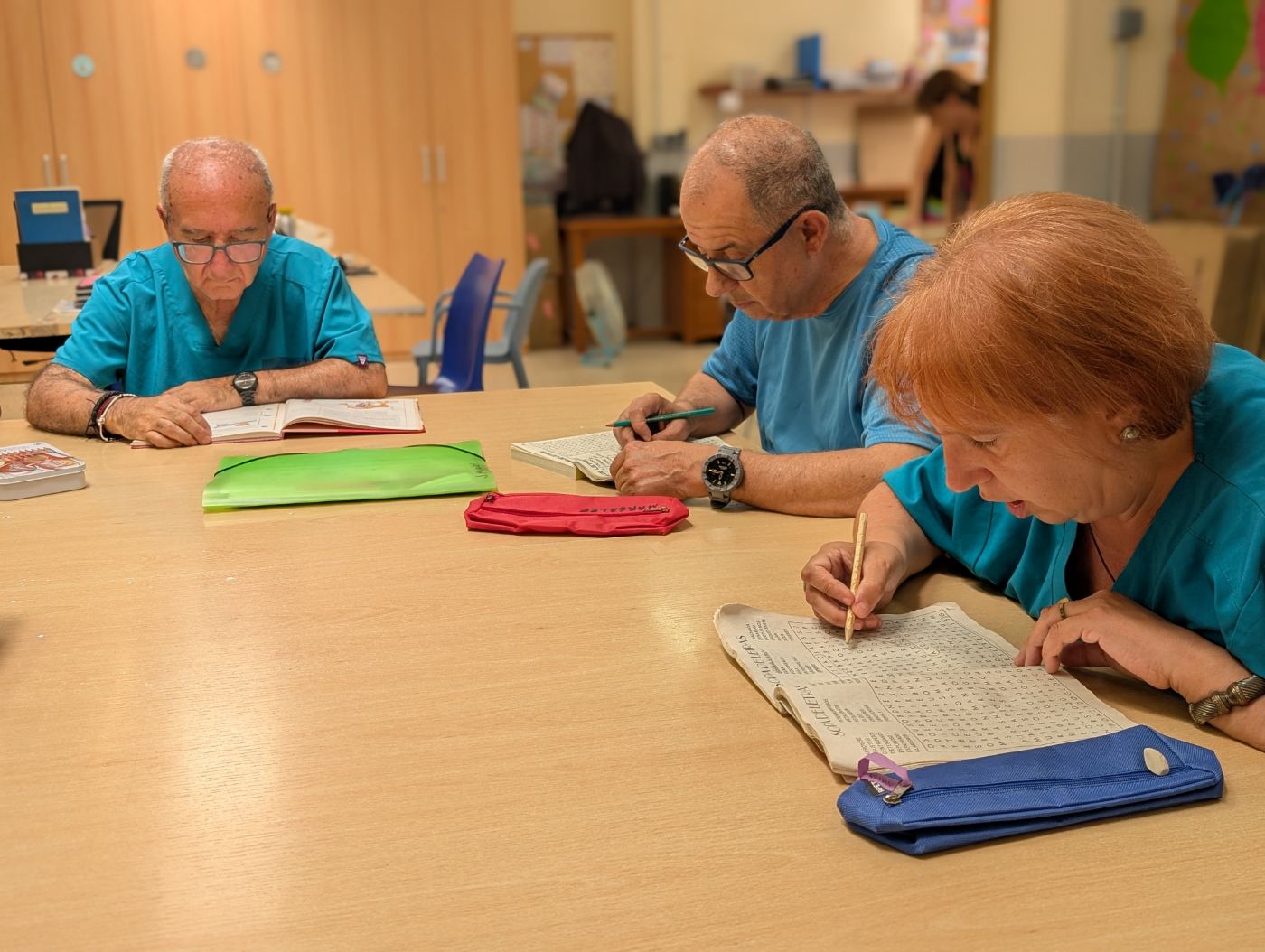 Persones grans fent sopa de lletres i activitats cognitives junts a la taula