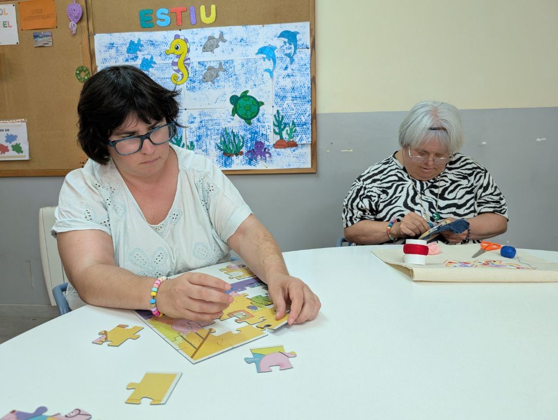 Persones grans fent un puzle i cosint en una activitat d'estimulació cognitiva